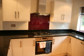 Star Galaxy worktops with red glass splash backs and window sill.Granite work tops Farnham Surrey