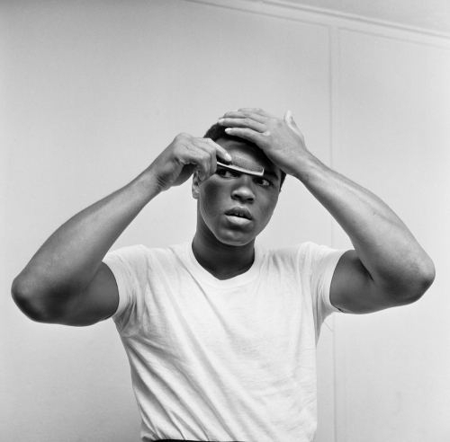 Cassius Clay combing his hair, he's in London for a bout with Henry Cooper. Muhammad Ali 12th May 1963