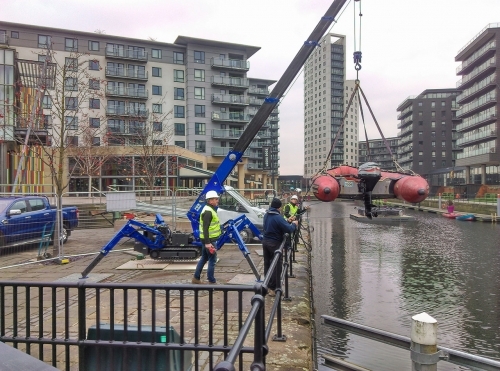 Crane launching boat on canal